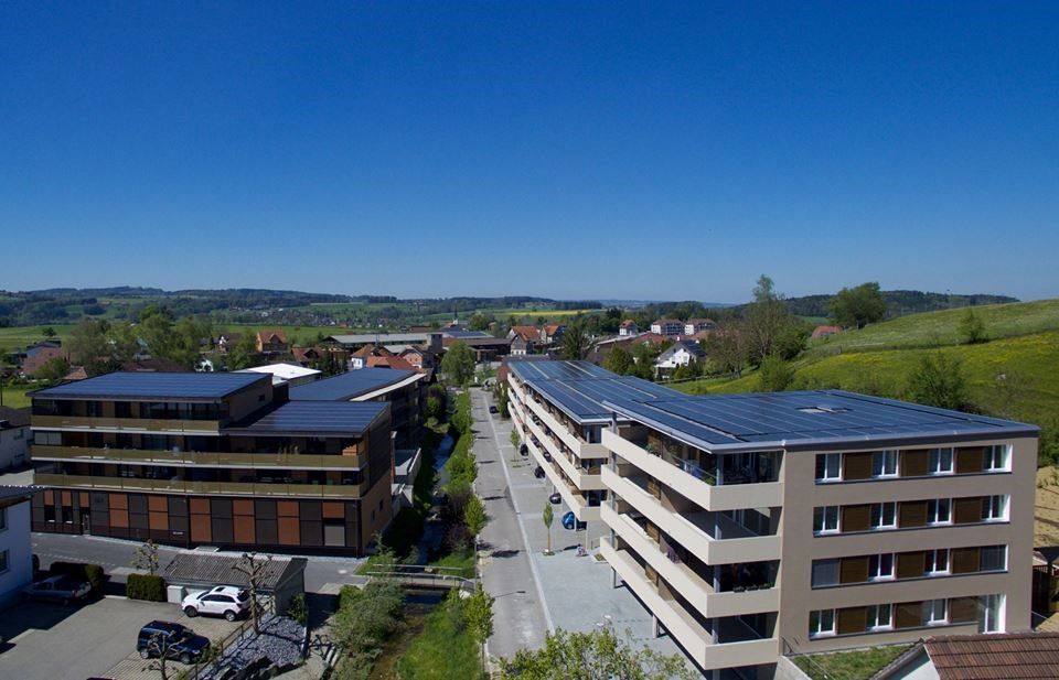 Die Abbildung zeigt Photovoltaikmodule auf den Flachdächern verschiedener Gebäude im Zentrum Tobel in der Schweiz.