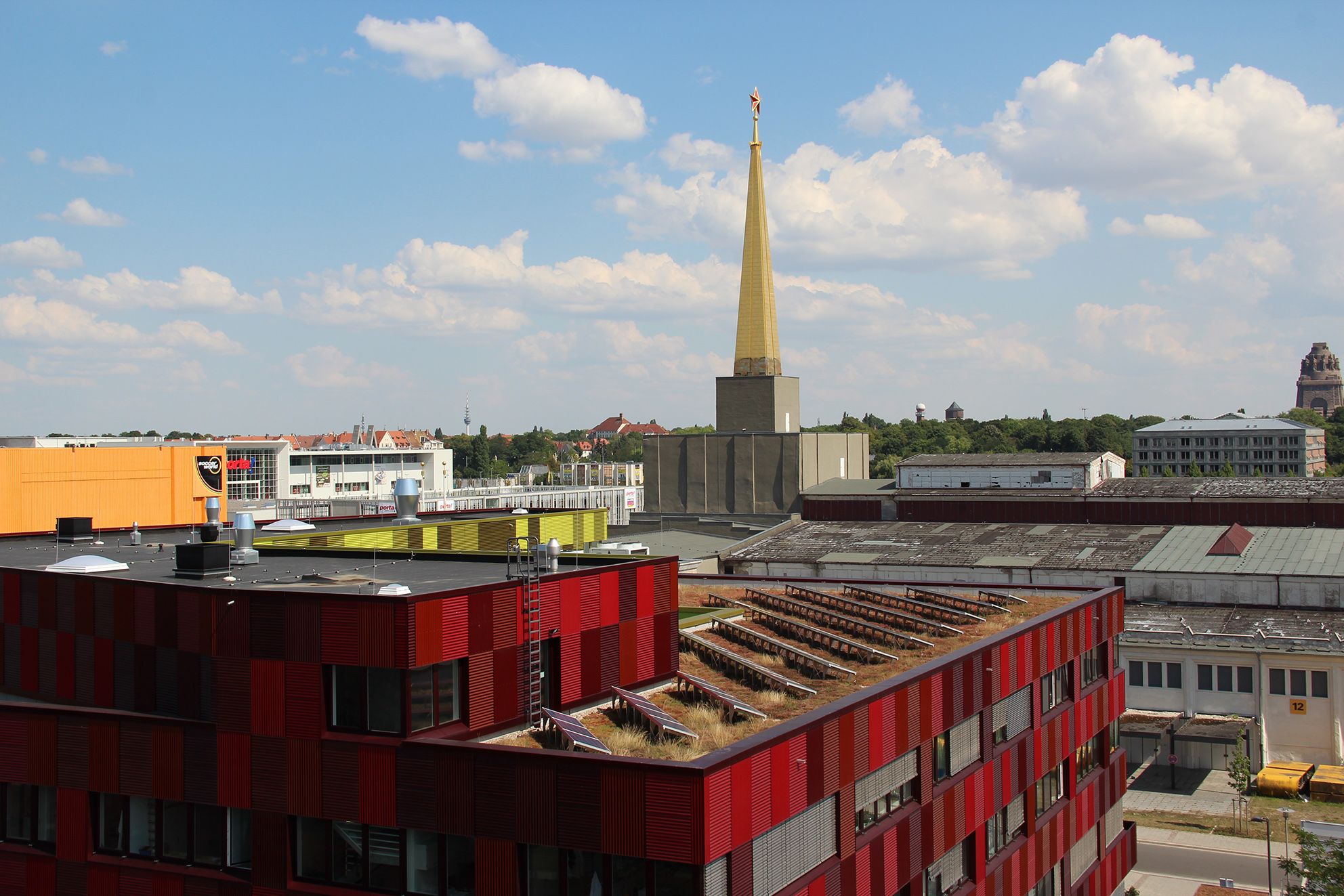 Das Foto zeigt das begrünte Flachdach mit PV-Anlage des Biocubes in Leipzig. 